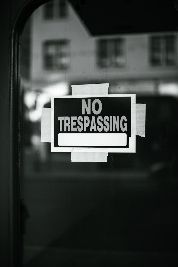 Black and White No Trespassing Sign on Glass Door