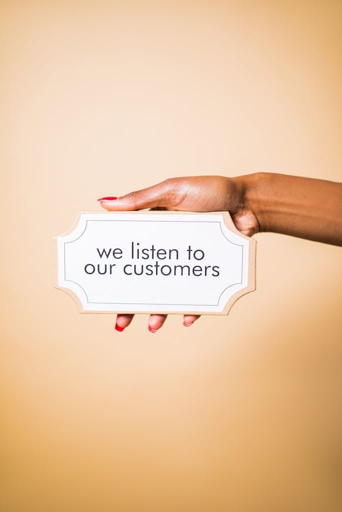 Person Holding a Board with a Text Saying "We Listen To Our Customers"